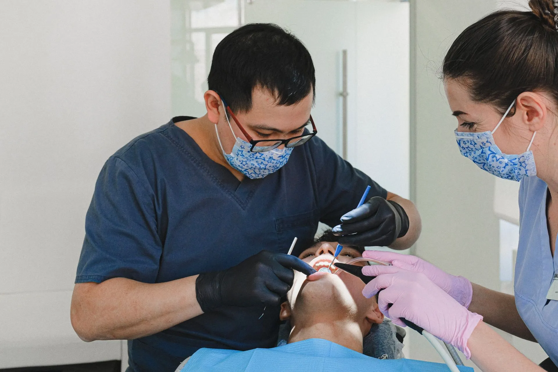 Dos profesionales realizando una revisión dental a un paciente en la Clínica Dental Dra. Ángeles Martínez